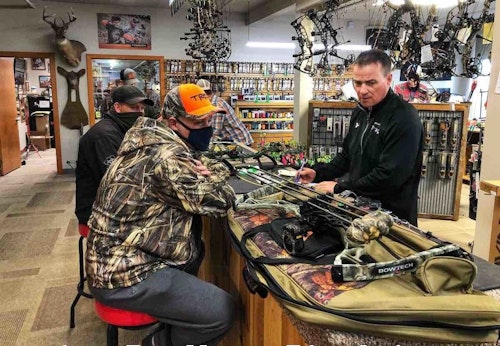 Al Krause, right, helps customers with bow repairs in his full-service pro shop. (Photo by Mark Kayser.)